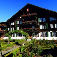 a building with a cow in front of it at Hotel Chalet Swiss, Interlaken