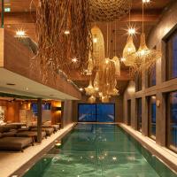 a swimming pool in a hotel with chandeliers at Hotel Walisgaden superior, Damuls