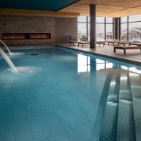 a swimming pool with a fountain in a building at HIGALIK HOTEL, Les Menuires
