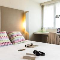 a room with a bed with two pillows and a desk at Campanile Valence Sud