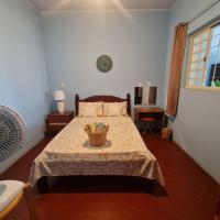 a bedroom with a bed with a table and a window at MAEVE Quarto Mata, Goiás