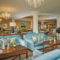 a living room with blue couches and a piano at Newpark Hotel, Kilkenny