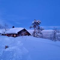 a house covered in snow in front at Heimstølen - Cabin at Sørbølfjell, Flå