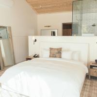 a large white bed in a bedroom with a wooden ceiling at Calamigos Guest Ranch and Beach Club, Malibu