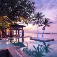 a pool with two palm trees and a house at Lub d Koh Samui Chaweng Beach - SHA Extra Plus