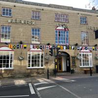 a building with flags on the front of it at The Warwick Arms Hotel