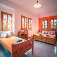 two beds in a room with orange walls and windows at Orange House for big families in Damouchari - Delicious Houses
