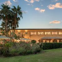 a building with palm trees in front of it at Hacienda Son Antem Golf Resort, Autograph Collection, Llucmajor