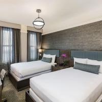 a hotel room with two beds and a desk at Handlery Union Square Hotel, San Francisco