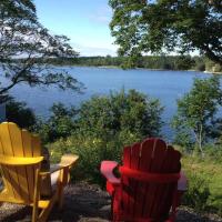 two chairs sitting in front of a lake at Oceanfront Cove Garden Cottage, Chester