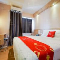 a bedroom with a large bed with a red blanket at RedLiving Apartemen Riverview Residence - at KINGDOM Tower Mahakam, Tegalgede
