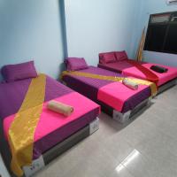 three beds in a room with pink yellow and purple at Haadrin village Fullmoon, Haad Rin