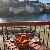 a table with a basket of bread and two cups of coffee at Chambre d'hôtes sur les bords de la Dordogne, Argentat