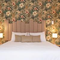 a bedroom with a large white bed with a floral wallpaper at The City Club, Cape Town