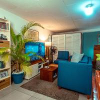 a living room with a blue couch and a table at PALM Springs Bed & Breakfast, Limbe