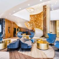 a lobby of a hotel with blue chairs and tables at Radisson Blu Belorusskaya, Moscow