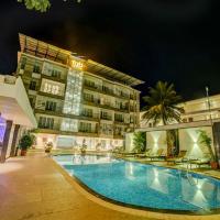 a swimming pool in front of a hotel at night at FabHotel Prime The King's Court, Calangute