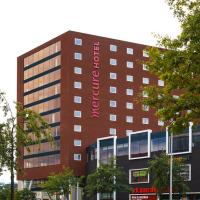 a tall building with a red sign on it at Mercure Hotel Amersfoort Centre