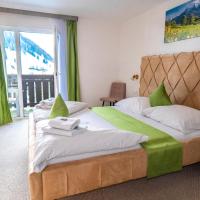 a bedroom with a large bed and a window at Hotel Sonnhof Rauris