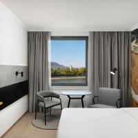 a hotel room with a bed and a table and a window at Danubius Hotel Helia, Budapest