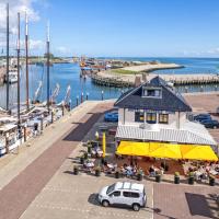 a view of a marina with a building with people sitting outside at Havenhotel Texel, Oudeschild