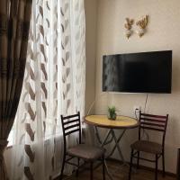 a room with a table and two chairs and a television at Baku House in Old City
