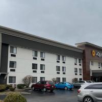 a hotel with cars parked in a parking lot at La Quinta Inn by Wyndham Indianapolis Airport Executive Dr