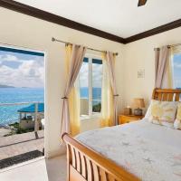 a bedroom with a bed and a view of the ocean at Anguilla - Snapper Suite villa, Blowing Point Village