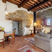 a living room with a dining room table and a stone wall at Rifugio sulla via di Volpaia, Radda in Chianti