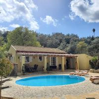 a villa with a swimming pool in front of a house at Villa Stefania, Agios Ioannis