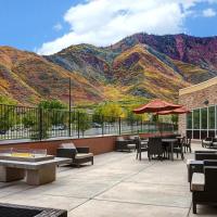 a patio with tables and chairs with mountains in the background at Courtyard by Marriott Glenwood Springs