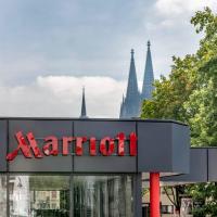 a marriott sign in front of a building with trees at Cologne Marriott Hotel