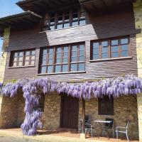 a house with wisteria on the front of it at La Casona de Soviña, Piloña