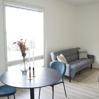 a living room with a table and chairs and a couch at New top floor apartment, Järvenpää