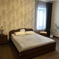 a bedroom with a bed and a wall with a window at Vesela Bdzhilka, Sumy