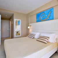 a bedroom with a large white bed with two pillows at Sidari Beach Hotel