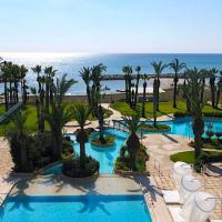 an aerial view of a resort with a pool and the ocean at Sentido Sandy Beach Hotel & Spa, Larnaca
