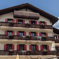 a building with balconies and flowers on it at Hotel Bahnhof, Zermatt