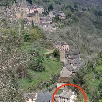 a red circle in a village on a hill at Le Castellou, Conques