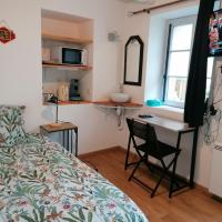 a bedroom with a bed and a desk and a sink at Mini Garni Vendémiaire, Vesoul