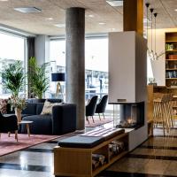 a lobby with a couch and chairs and a fireplace at Aalborg Airport Hotel