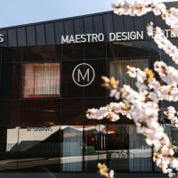 a masuedo design building with a tree in front of it at Maestro Design Hotel, Liepāja