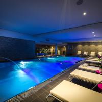 a large swimming pool in a hotel with lounge chairs at H&ocirc;tel Restaurant Athena Spa, Strasbourg