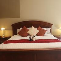 a bed with a teddy bear sitting on top of it at Farmhouse Suite, Port Hope