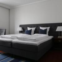 a bedroom with a large bed with blue pillows at Helnan Phønix Hotel, Aalborg
