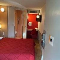 a hotel room with a red bed and a bathroom at Premiere Classe Blois Nord