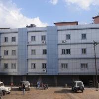 a white building with cars parked in a parking lot at Hotel Barbareek, Shillong