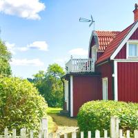 a red house with a fence in front of it at Holiday home VIMMERBY IV, Vimmerby