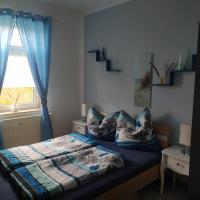 a bedroom with a bed with blue curtains and a window at Ferienwohnung am Tierpark Weißwasser