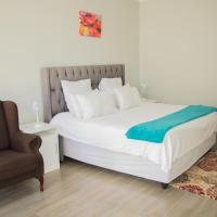 a bedroom with a bed and a chair at Standard room in Morningside guesthouse - 2090, Bulawayo